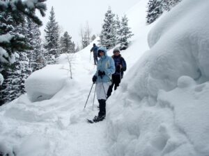 Snowshoes in deep snow on a guided snowshoeing tour