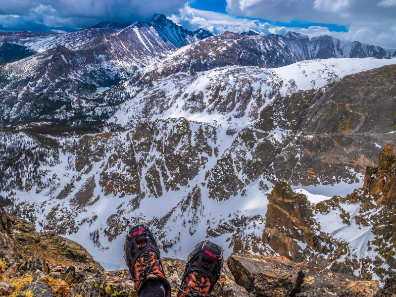 hiker sits on a ridge overlook Rocky Mountain National Park